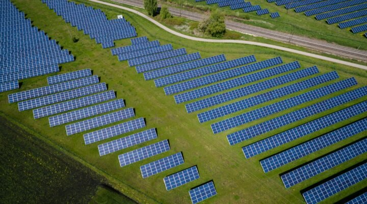 aerial photography of grass field with blue solar panels